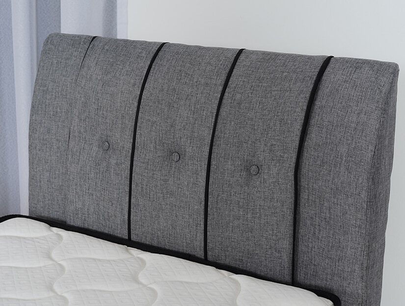 Padded, button-tufted headboard with piped seams.