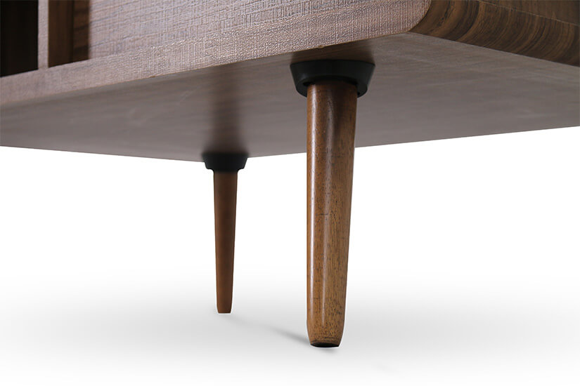 The coffee table is supported by round tapered solid wooden legs.