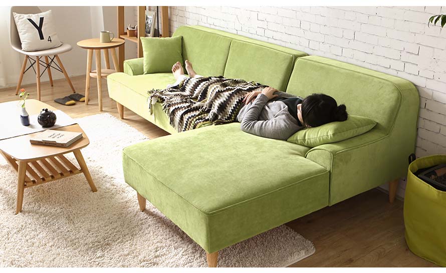 Lying down sleeping on the green colored dile sofa