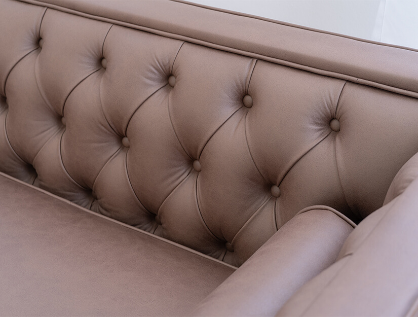 Diamond-shaped deep button tufting along the backrest and armrests. Elegant and intricate craftmanship.