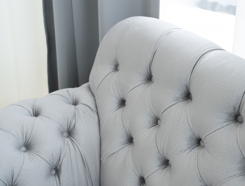 Diamond-shaped deep button tufting along the backrest and armrests. Timeless elegance.