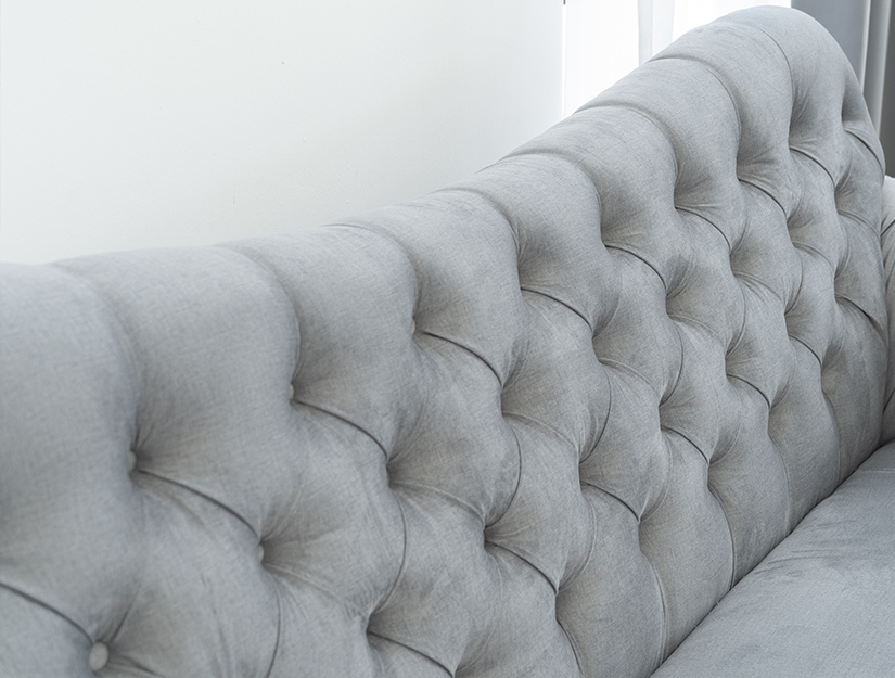 Diamond-shaped deep button tufting along the backrest and armrests. Timeless elegance.